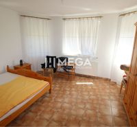 A bedroom with wooden furniture and tiles in a family house.