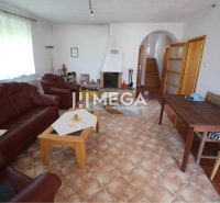 Living room of a family house with a fireplace, leather furniture, and tiled floor.