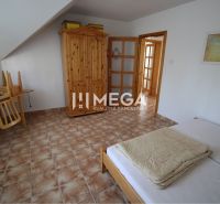 A bedroom in a family house with wooden furniture and tiles.