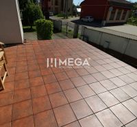 Terrace of a family house in Pčoliné on Pčoliné Street with brick paving and a wooden bench.