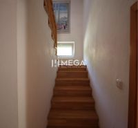 A staircase in a family house with a wooden decor floor and a window on the wall.