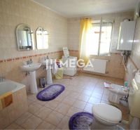A spacious bathroom with two sinks, a bathtub, and a window in a family house.
