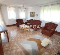 Living room in a family house with leather armchairs and a carpet on the tiles.