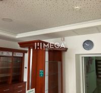 The interior of a building with glass display cases and a clock on the wall.