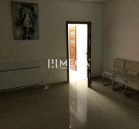Interior of a building with white chairs, a painting, and open doors with a verification sticker.