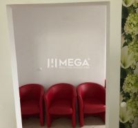 Three red armchairs with white walls and floral wallpaper in a building.