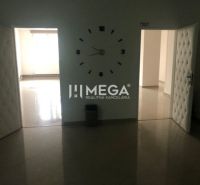 The interior of a building with prominent clocks on the wall and open doors.