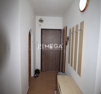 Hallway of a 2-room apartment with a coat rack, shoe cabinet, and brown tiles.