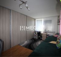 A room with a wooden floor decor, a built-in wardrobe, and a desk in a 2-room apartment.