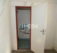 A small room with a sink and white walls in commercial premises.