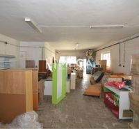 Commercial premises with stored shelves, boxes, and equipment, floor with wooden decor.