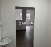 Interior of commercial premises with a sink and doors, floor with wooden decor.