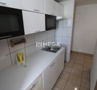 A kitchen in a 3-room apartment with white cabinets and tiled flooring.