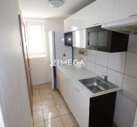A kitchen in a 3-room apartment with white cabinets and ceramic tiles.