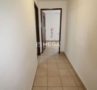 A hallway with light walls and tiles in a 3-room apartment.