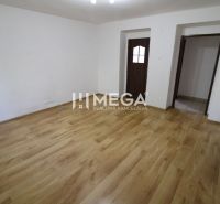 A room in a 3-room apartment with a wooden decor floor and white walls.