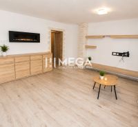 Living room in a 3-room apartment with wood-patterned flooring, light-colored walls, and furniture.