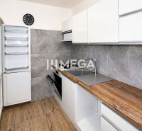 A kitchen in a 3-room apartment with a wooden decor floor and modern appliances.