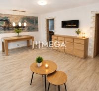 A stylish living room in a three-room apartment with a wooden decor floor.