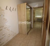 Hallway of a 3-room apartment with a tiled floor, mirrored wardrobe, and a wall with stone cladding.
