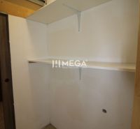 Storage space with shelves in a 3-room apartment, white walls and light flooring.