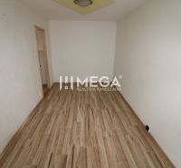 A room in a three-room apartment with a wooden decor floor and white walls.