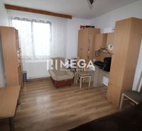 A room with wooden decor, furniture, an armchair, and a table in a family house.