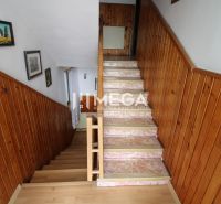 A staircase in a family house with wooden paneling, a floor with a wooden decor, decorations on the walls.