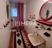 Bathroom in a family house with tiles and a mirror with a red frame.