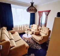 Living room in a family house with beige sofas, carpet, and chandeliers.
