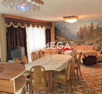Living room in a family house with a carpet, picture wallpaper, and a round table.