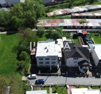 Family houses on Gagarin Street in Snina, surrounded by greenery and neighboring buildings.