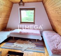 Attic room in a cottage with three beds and a floor with a wooden decor.