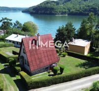 A cottage by the reservoir in Nová Kelča surrounded by greenery and a landscaped garden.