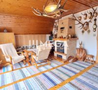 Interior of a cabin with a fireplace, wood paneling, and antler decorations.