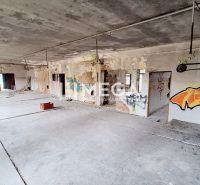 Abandoned building interior with graffiti and raw concrete floor.
