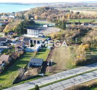 Panoramic view of residential plots in Vinné with a nearby lake.
