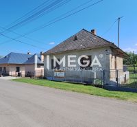 A family house in Kochanovce on Kochanovce Street, with a lawn and a fence, clear sky.