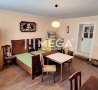 A room in a family house with a bed, furniture, and a wooden decor floor.