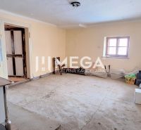A room in a family house with a simple kitchen stove and a concrete floor.