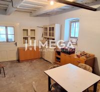 A room in a family house with older furniture and a table, without decorative flooring.