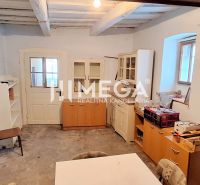 Interior of a family house with a wooden ceiling, old doors, and furniture.