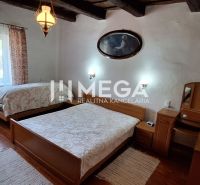 A bedroom in a family house with wooden beams and a floor with a wooden decor.