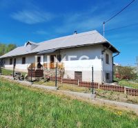 A family house in the village of Zbudská Belá surrounded by green lawns and trees.
