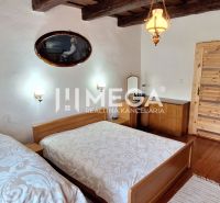 A bedroom with two beds, a wooden ceiling, and a floor with a wooden decor in a family house.