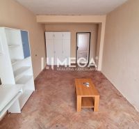 Living room in a two-room apartment with white furniture and a wooden decor floor.