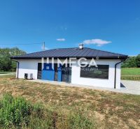 A family house in Jasenov built on a green plot with a blue sky.