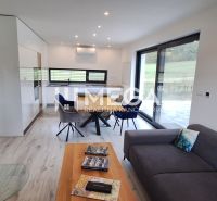 Living room with a fireplace and wood-patterned flooring in a family house.