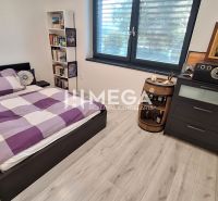 A bedroom in a family house with a bed, shelves, a dresser, and a floor with a wooden decor.