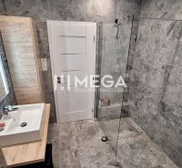 A bathroom in a family house with stone cladding and a shower enclosure.